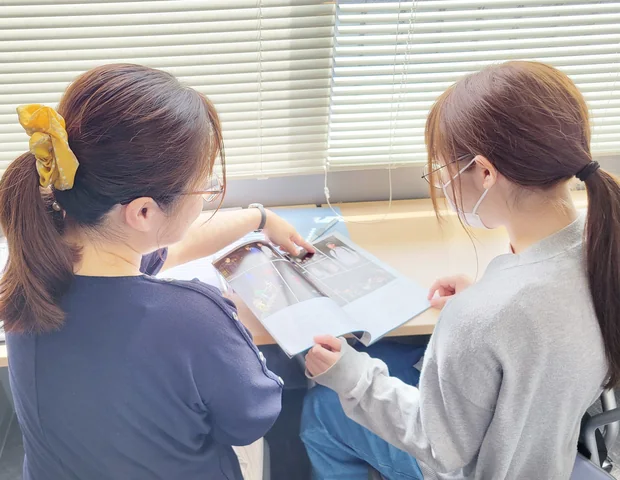 進路資料を確認する生徒と先生