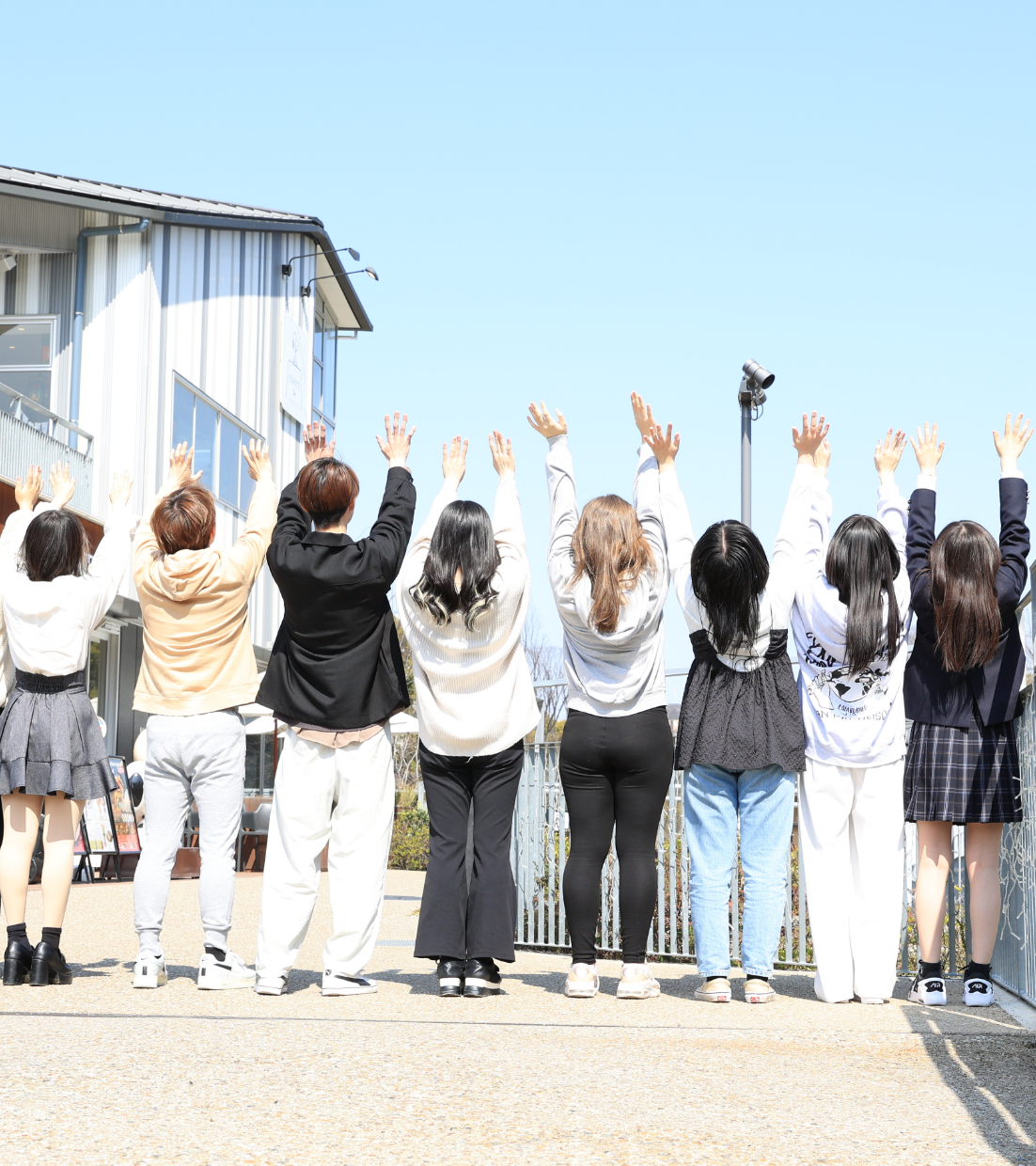 青空に向かって手を伸ばす生徒たち