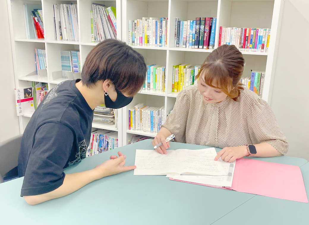 先生と生徒が机を囲んで学習する様子